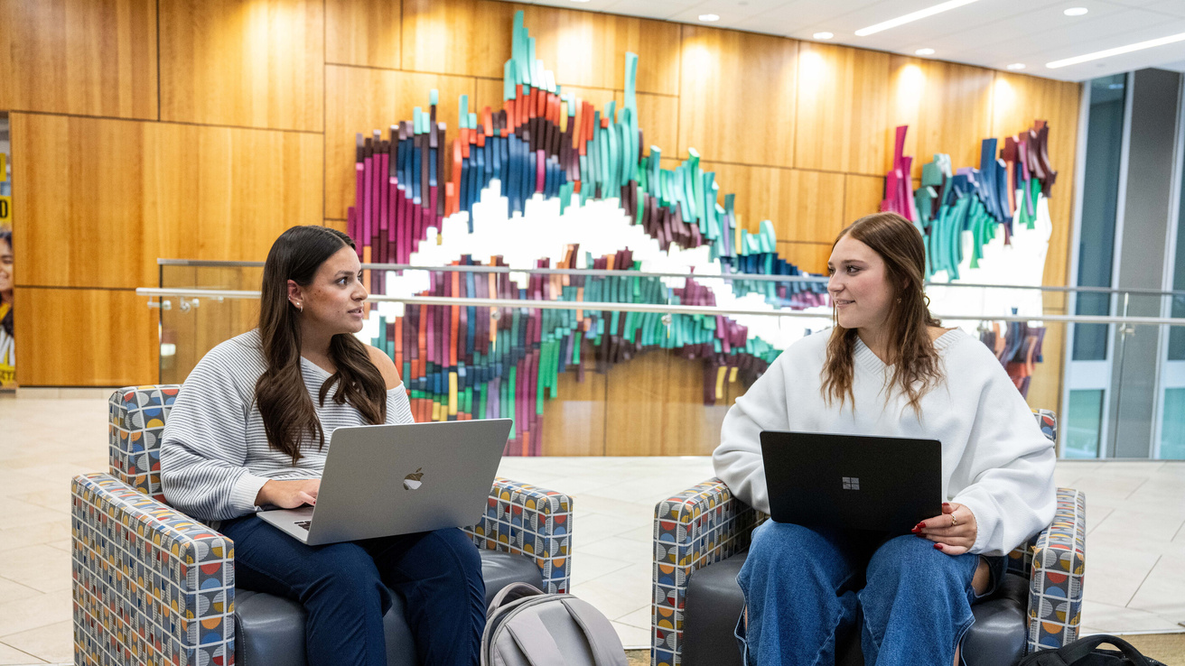 Two students on laptops in Petersen Residence Hall
